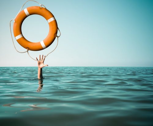 Drown man with rised hand getting lifebuoy help in sea or ocean