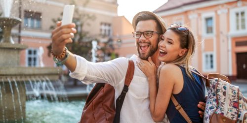 Happy tourist couple in love dating, laughing on vacation